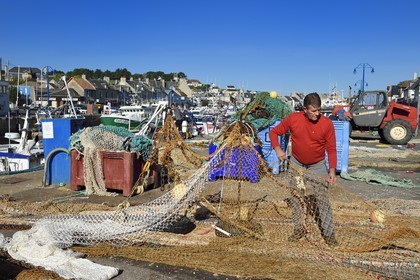 France, Calvados (14), Cote de Nacre, Port-en-Bessin, le port de pêche, pecheur réparant des filets