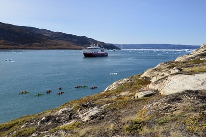 Groenland, cote ouest, baie de Disko, baie de Quervain, kayaks progressant au milieu des icebergs, le bateau de croisière MS Fram de la compagnie Hurtigruten en arrière plan