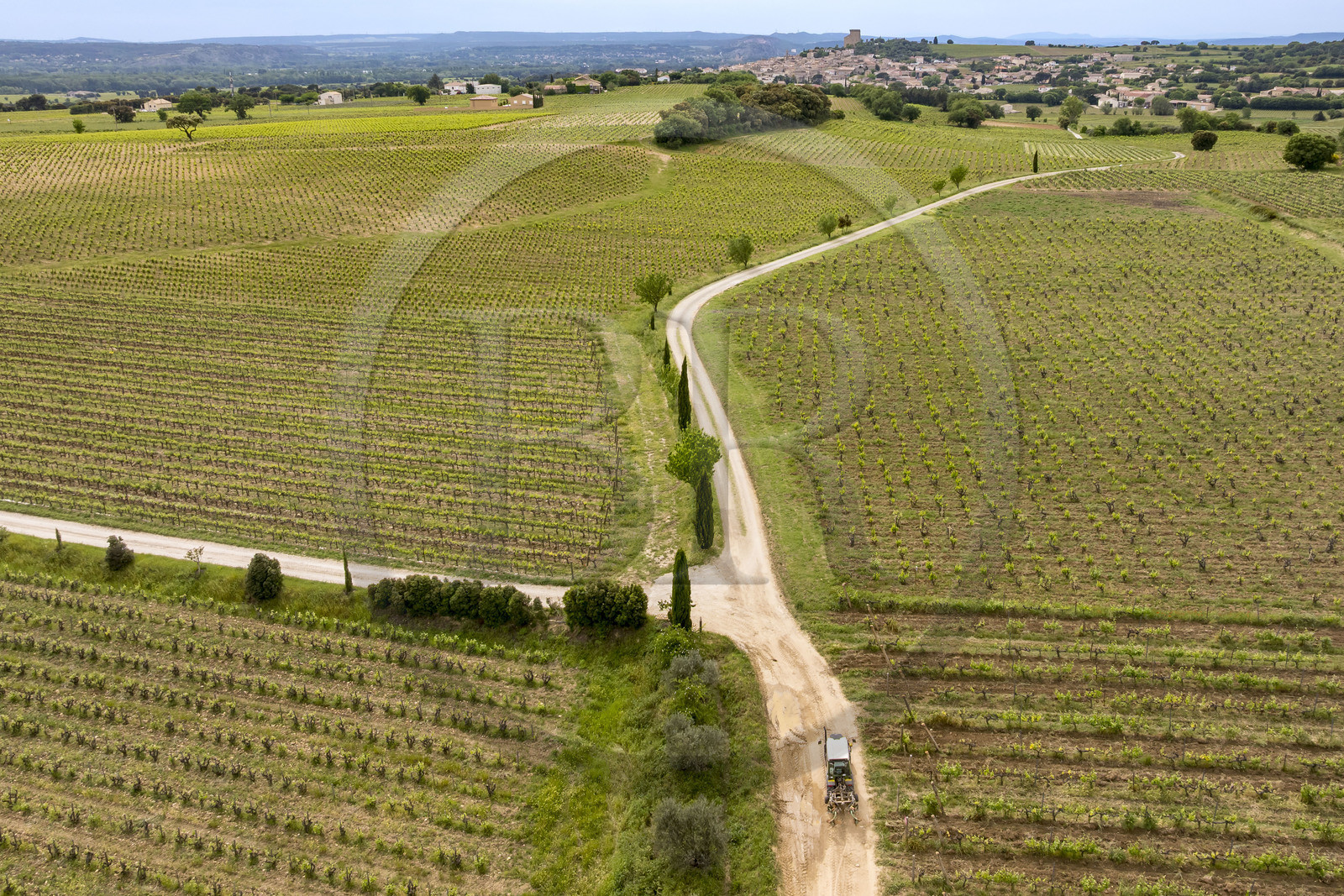 France, Vaucluse (84), Châteauneuf-du-Pape, tracteur viticole sur le chemin Coste Froide sur le plateau de la Crau et le donjon de Châteauneuf-du-Pape en arrière plan (vue aérienne)