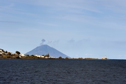 Italy, Sicily, Aeolian Islands, listed as World Heritage by UNESCO, Lighthouse of the village of Lingua on Salina Island, the Stromboli volcano in the background