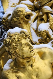 France, Yvelines, snow covered park of the Chateau de Versailles, listed as World Heritage by UNESCO, detail of a statue of the Triumphal Arch Grove