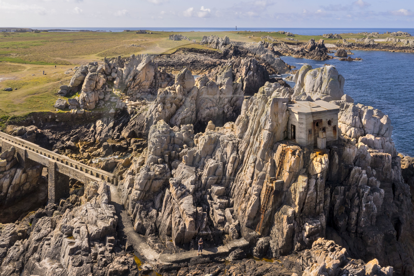 France, Finistère (29), Mer d'Iroise, Ile d'Ouessant, rochers façonnés par les tempêtes au pied du phare du Créac’h, pont menant au batiment de l'ancienne corne de brume (vue aérienne)