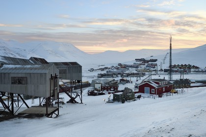 Norvège, Svalbard, Spitzberg, Longyearbyen, la ville et au premier plan le batiment central abandonné du téléphérique utilisé pour le transport des chariots de charbon des mines vers le port