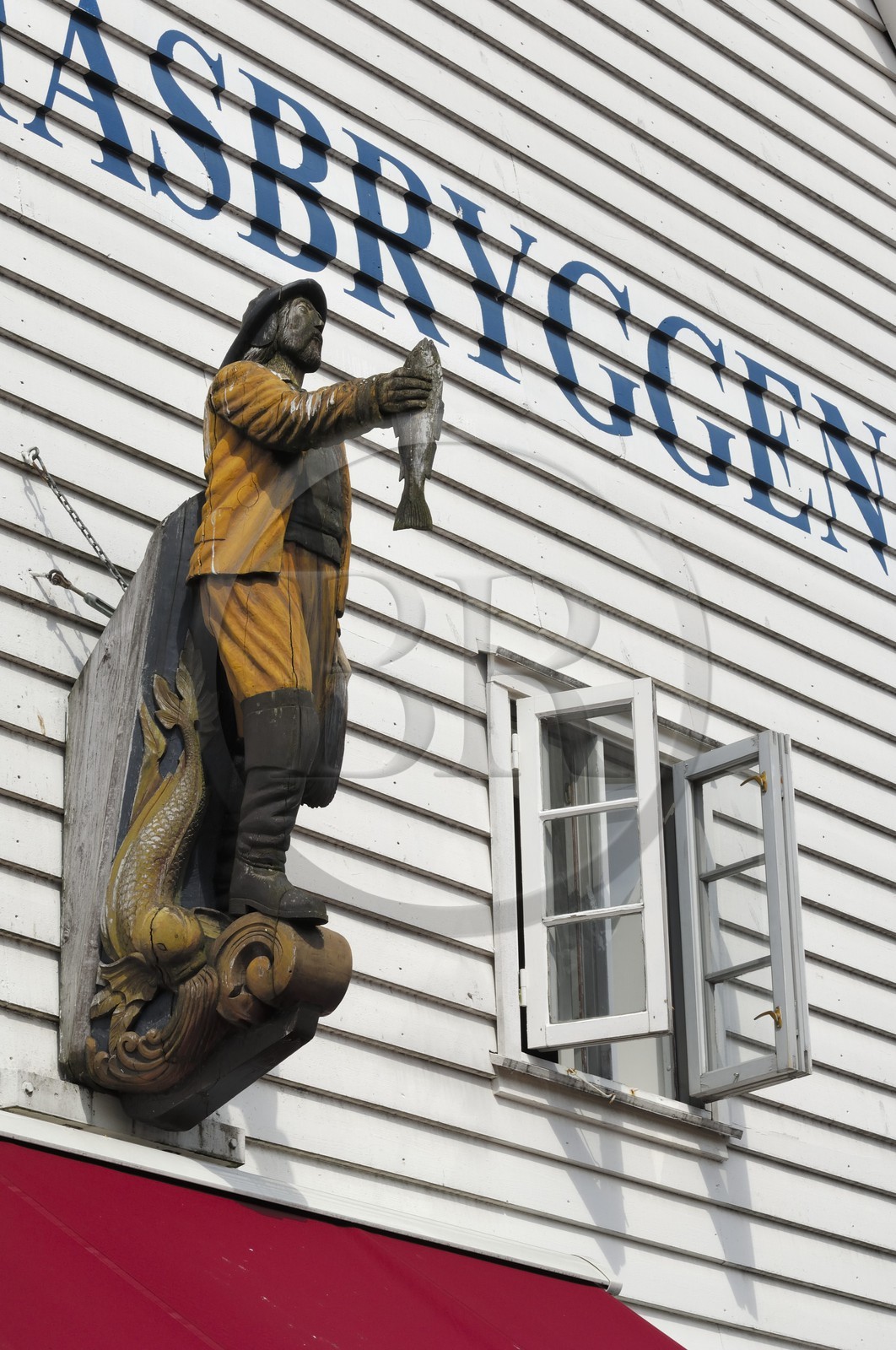 Norvège, Hordaland, Bergen, statue de pêcheur sur la facade d'une maison en bois