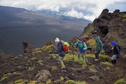 Italie, Sicile, Parc naturel régional de l’Etna, le Mont Etna, classé Patrimoine Mondial de l'UNESCO, randonneurs en bordure de la Valle del Bove qui correspond à un effondrement d’une des parois de l’Etna créant un champ de roches volcaniques de 7 km par 6 km