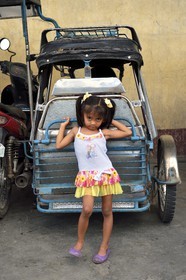 Philippines, province de Tarlac, Victoria, fillette devant un tricycle moto-taxi