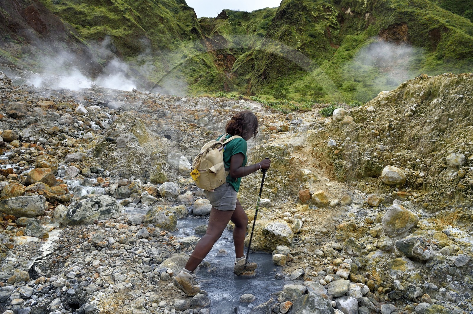 Caribbean, Dominica Island, Castle Bruce, Morne Trois Pitons National Park listed as World heritage by UNESCO, Valley of Desolation, hiker crossing a river of hot springs, whose unique color is due to the presence of calcium, carbon, sulfur and iron, on the trail leading to Boiling Lake