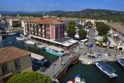 France, Var, Gulf of St Tropez, the Port Grimaud seaside town, the market place and the old village of Grimaud in the background on the left
