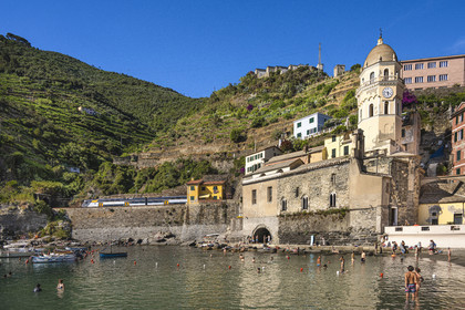Italie, Ligurie, Cinque Terre, parc national des Cinque Terre classé Patrimoine Mondial de l'UNESCO, village de Vernazza, l'église paroissiale de Sainte Marguerite d'Antioche (Santa Margherita) flanquée d'un haut clocher octogonal et passage du train