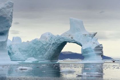 Groenland, cote Nord-Ouest, mer de Baffin, Inglefield Fjord vers Qaanaaq, iceberg formant un arche et un PolarCirkel boat (zodiac) d'exploration du bateau de croisière MS Fram de la compagnie Hurtigruten