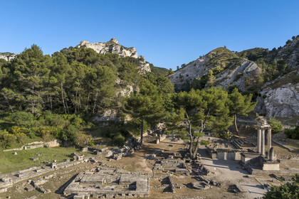 France, Bouches-du-Rhône (13), Parc Naturel Régional des Alpilles, Saint-Rémy-de-Provence, site archéologique de Glanum au pied du massif des Alpilles, colonnes et entablement reconstitués du petit temple géminé du premier forum au premier plan à droite (vue aérienne)