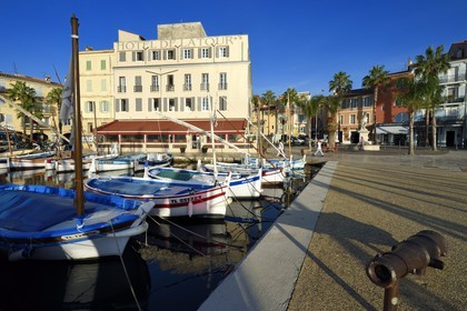 France, Var, Sanary-sur-Mer, traditional fishing boats called pointus in the port, Hotel de la Tour that wraps the Romanesque 13th century tower in the background