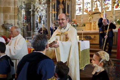 France, Finistere, Locronan, labelled Les plus Beaux Villages de France (The Most Beautiful Villages of France), Saint Ronan church, procession of the small Troménie, the priest gives the coasts relics of St. Ronan to kiss