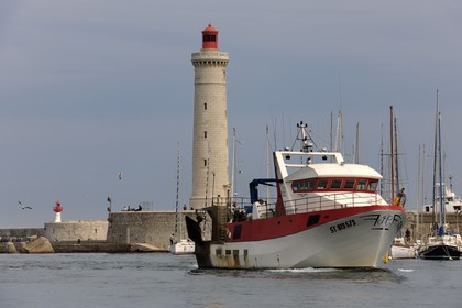 France, Herault, Sete, Vieux Port (Old harbour), fishing return of a trawler and the lighthouse of the jetty St. Louis (Mole St. Louis