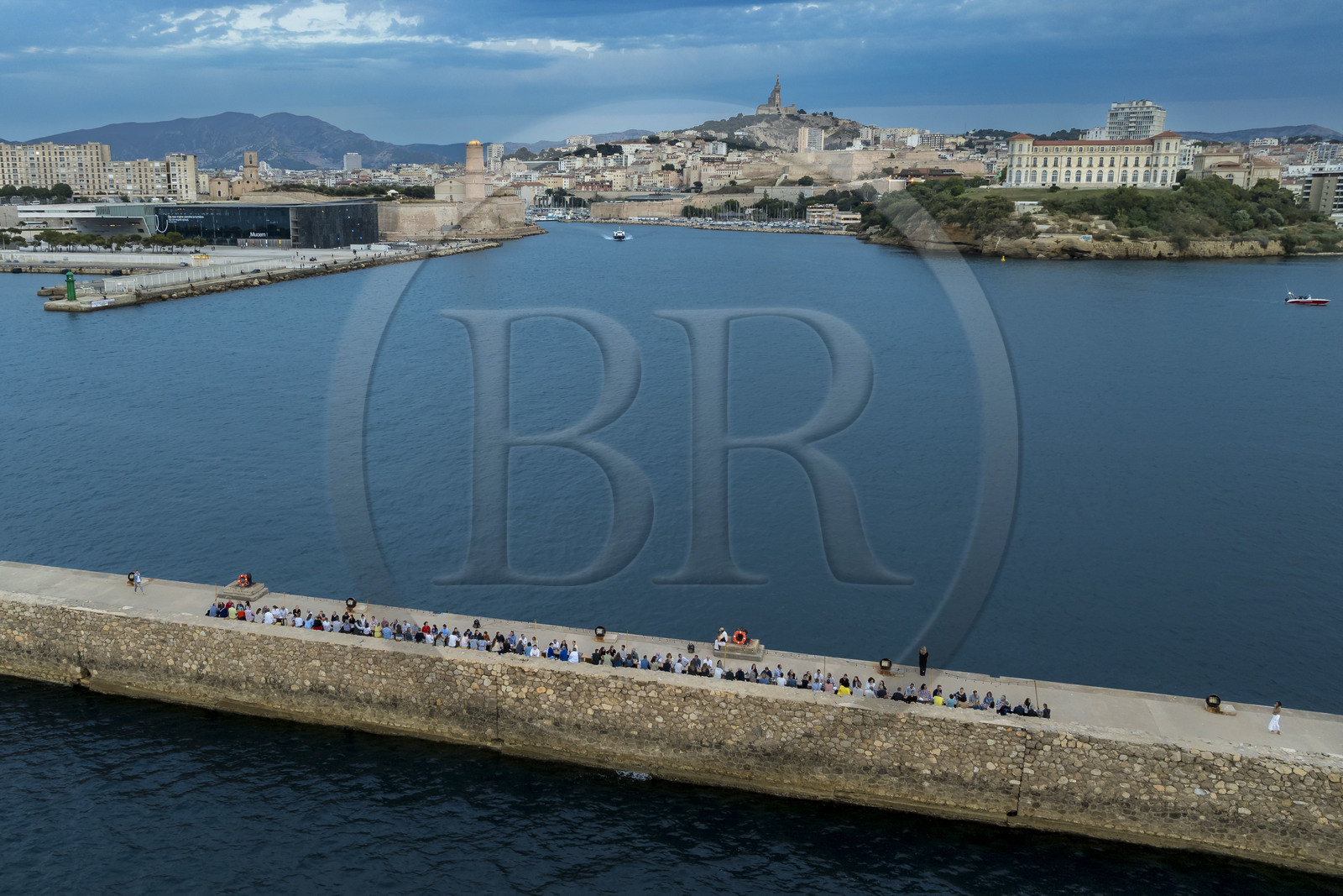 France, Bouches-du-Rhône (13), Marseille, Zone Euroméditerranée, grand port maritime de Marseille (GPMM), la digue du large, convives attablés à une grand table de banquet dressée par le chef Emmanuel Perrodin dans le cadre des Diners Insolites, le Mucem, le Fort Saint-Jean et la basilique Notre Dame de la Garde en arrière plan (vue aérienne)