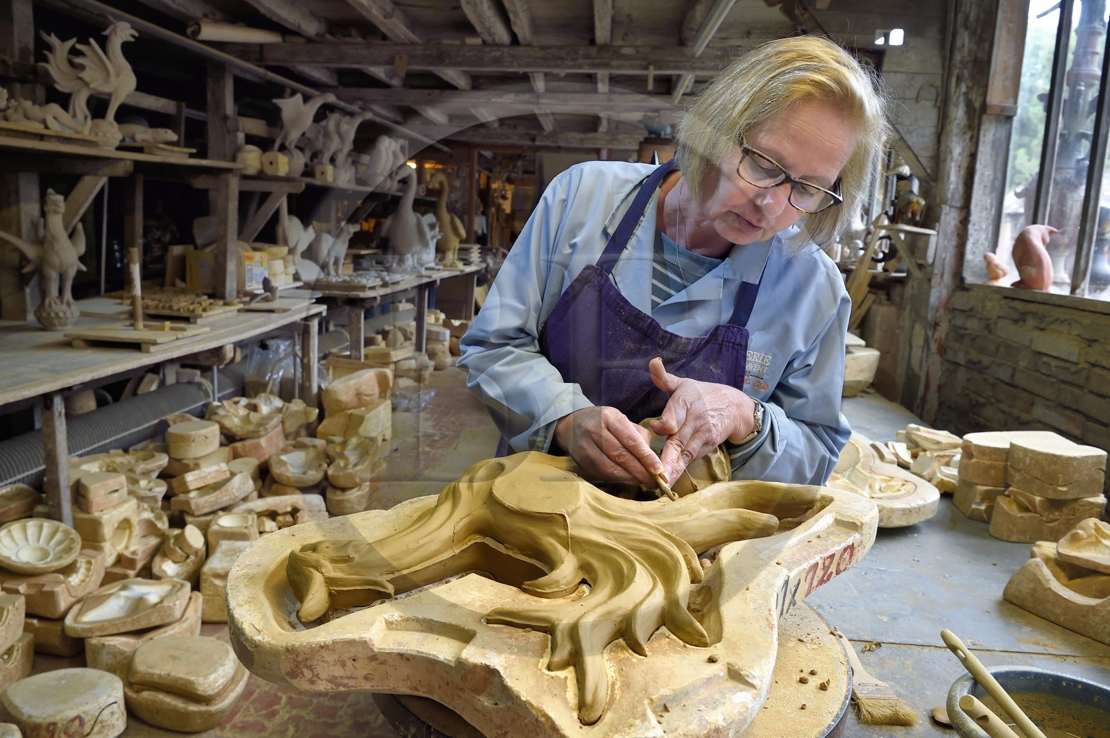 France, Calvados (14), Pays d'Auge, Bavent, poterie du Mesnil de Bavent, la céramiste Annie Richier au démoulage et finition d'un épi de faitage représentant un coq dans l'atelier