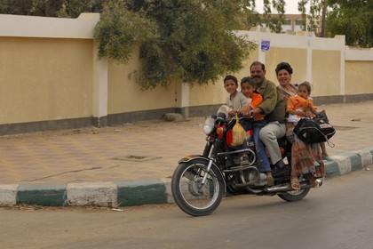 Egypte, Haute Egypte, désert libyque, oasis de Kharga, famille sur une moto dans la ville de Kharga