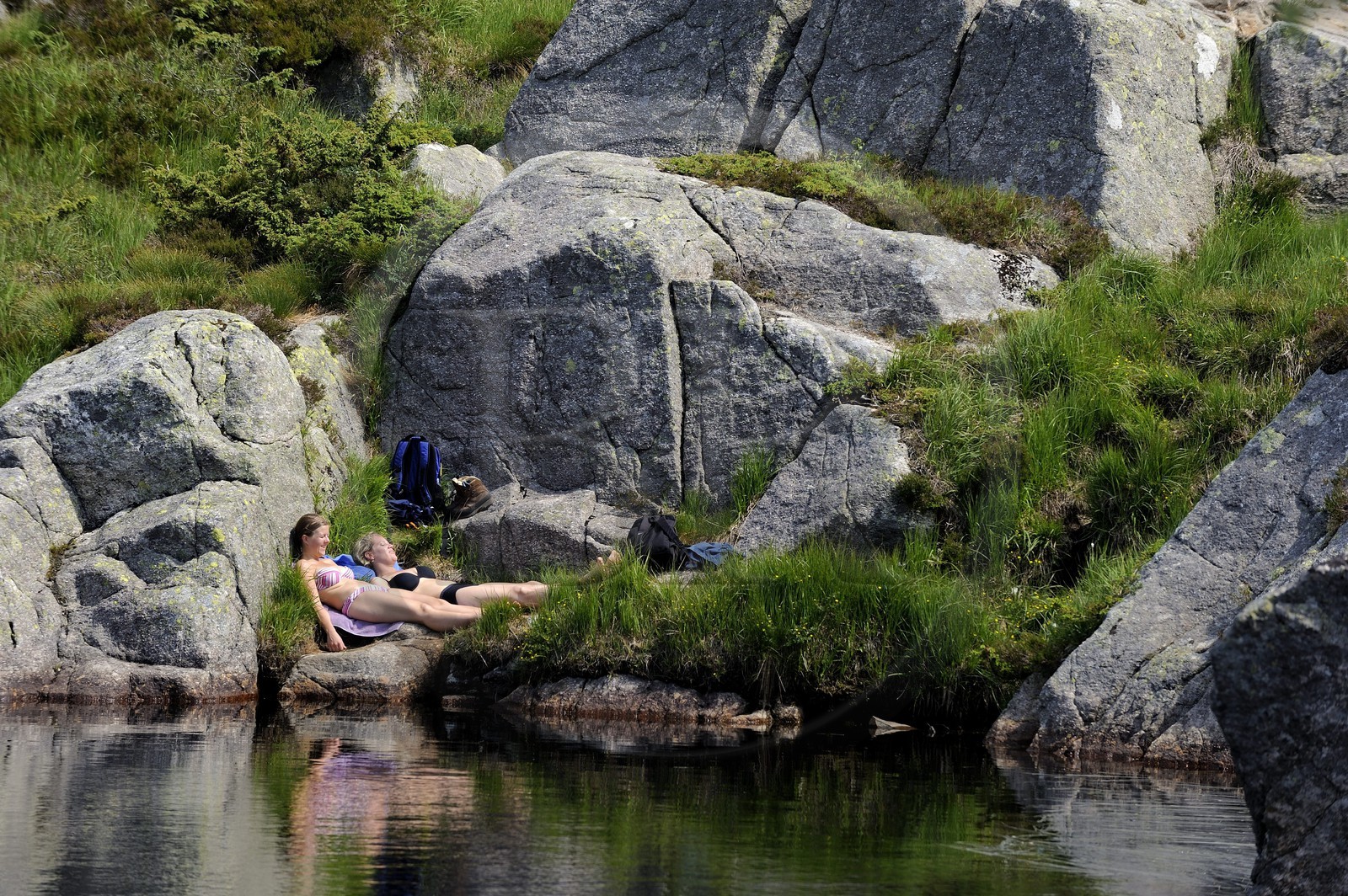 Norvège, Rogaland, région du Lysefjord, randonneurs se reposant au bord d'un petit lac sur le chemin de randonnée menant au Rocher de La Chaire (Preikestolen)