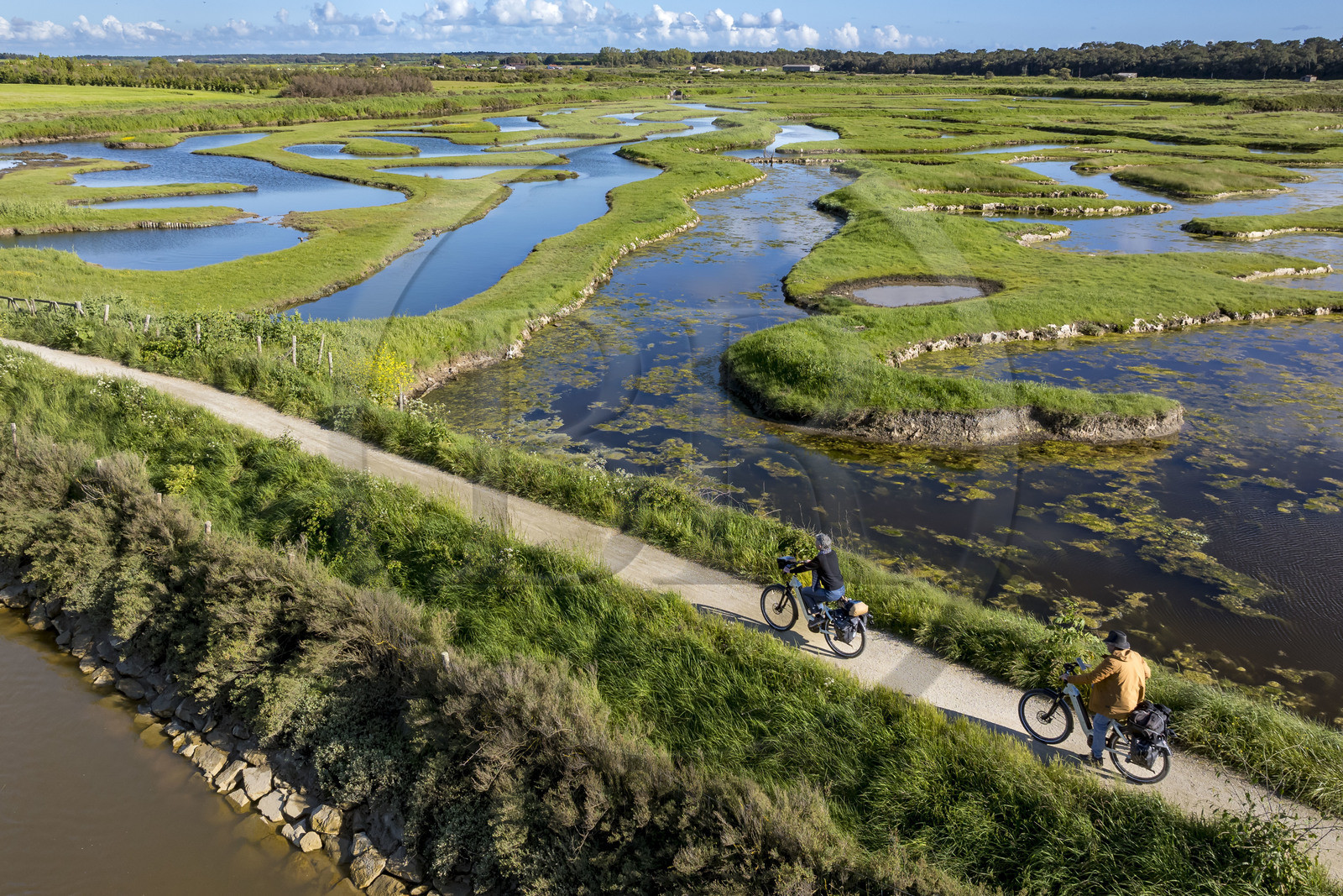France, Vendée (85), Talmont Saint Hilaire, Guittière marshes in the hinterland of Pointe du Payré, cyclist on the Vendée Vélo Tour and Vélodyssée cycle route et the passage du Cul d’Ane, marshes developed for fish farming of sea bream, mullet and eels (aerial view)