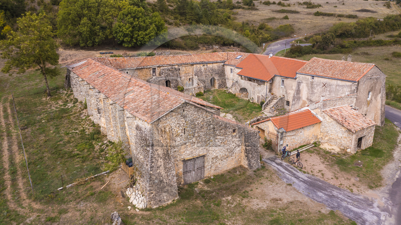 France, Aveyron (12), parc naturel régional des Grands-Causses, cyclistes effectuant l'itinéraire cyclo touristique Brebis'Cyclette en Pays de Roquefort, Ferme de Mascourbe qui appartenait à la commanderie des Hospitaliers de Saint-Jean de Jérusalem (vue aérienne)