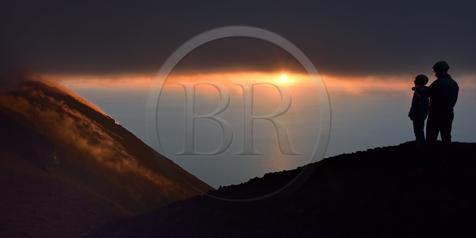 Italie, Sicile, iles Eoliennes, classées Patrimoine Mondial de l'UNESCO, ile de Stromboli, randonneurs observant les fumerolles d'une éruption sur les pentes du volcan actif au coucher de soleil