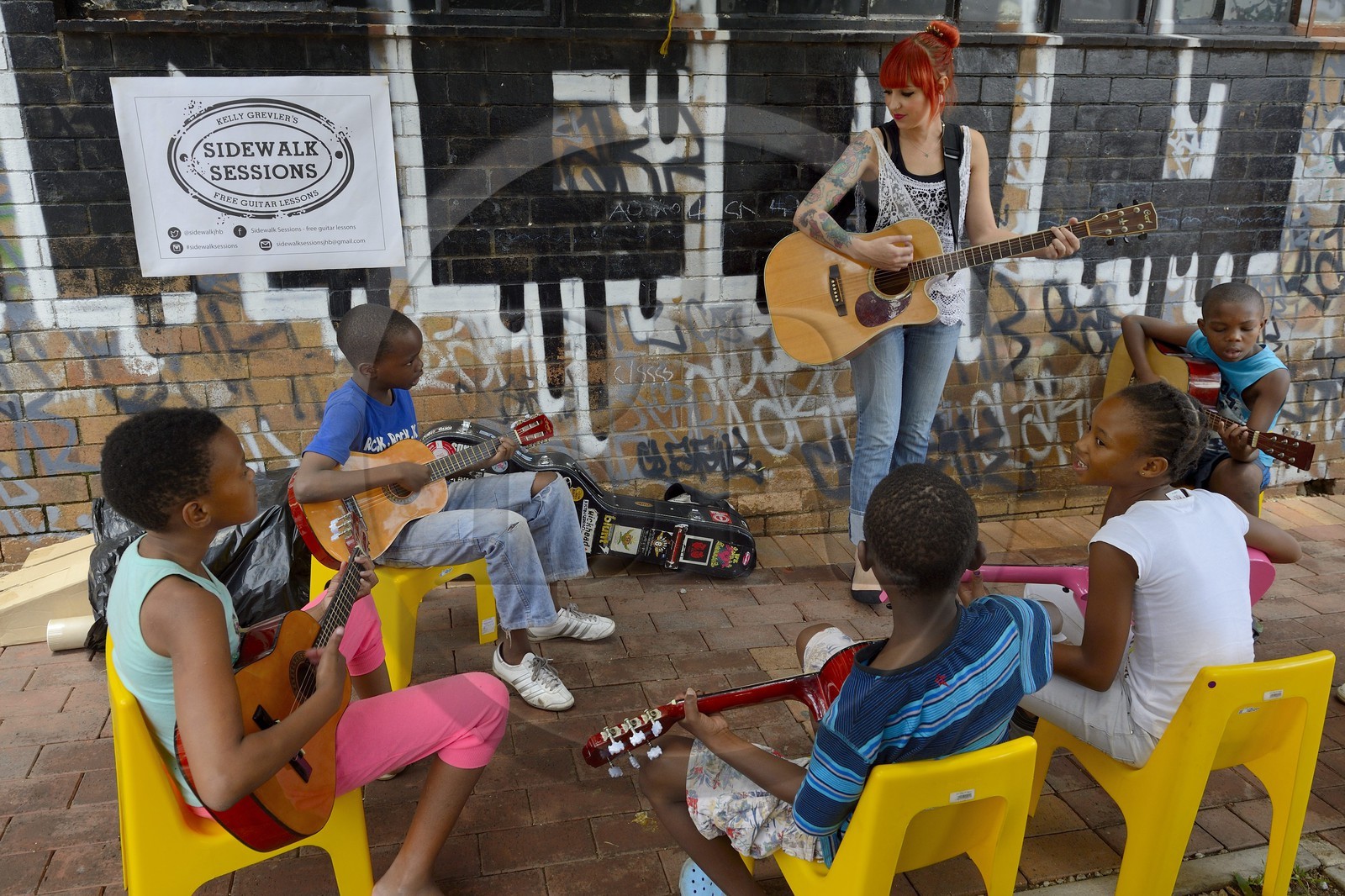Afrique du Sud, province de Gauteng, Johannesburg, CBD (Central Business District), quartier de Maboneng, Sidewalk Sessions dans Fox street, Kelly Grevler donne des cours de guitare gratuits pour de jeunes enfants dans la rue