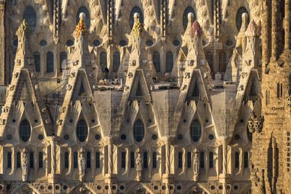 Espagne, Catalogne, Barcelone, quartier de l'Eixample, basilique de la Sagrada Familia de l'architecte du modernisme catalan Antoni Gaudi classée Patrimoine Mondial de l'UNESCO, sommets surmontés de mosaïques en forme de fruits entourant le chantier sur le toit de la nef ici côté facade de la Passion
