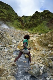 Caraïbes, Ile de la Dominique, Castle Bruce, Parc national du Morne Trois Pitons classé Patrimoine Mondial de l'UNESCO, la Vallée de la Désolation, randonneuse traversant une rivière aux sources d'eau chaude dont la couleur unique est due à la présence de calcium, de carbone, de soufre et de fer, sur le sentier menant au Boiling Lake