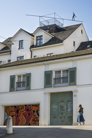 Switzerland, Basel, Old town of Greater Basel (left bank), a silhouette of a metal tightrope walker dancing on a roof, street-art in Heuberg street