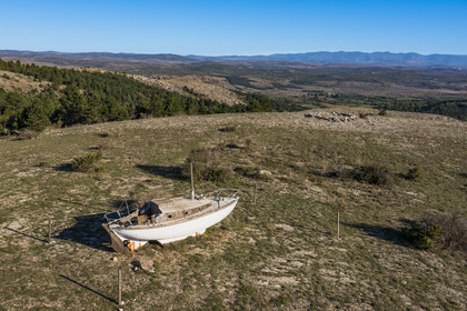 France, Herault, the Causses and the Cevennes, Mediterranean agro pastoral cultural landscape, listed as World Heritage by UNESCO, La Vacquerie et Saint Martin de Castries, old sailboat stranded on a height overlooking the Larzac plateau like Noah's Ark (aerial view)