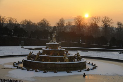 France, Yvelines (78), parc du château de Versailles sous la neige, classé Patrimoine Mondial de l'UNESCO, le Bassin de Latone au soleil couchant