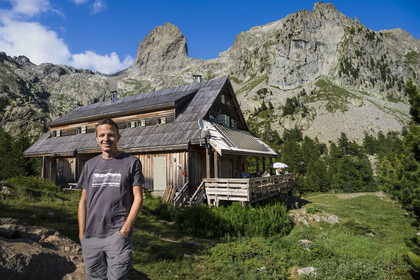 France, Alpes-Maritimes (06), parc national du Mercantour, Haute-Vésubie, Saint-Martin-Vésubie, Val du Haut Boréon, Manuel Putelat, gardien du refuge de Cougourde et le sommet frontalier du Caïres de Cougourde (2892m) en arrière plan