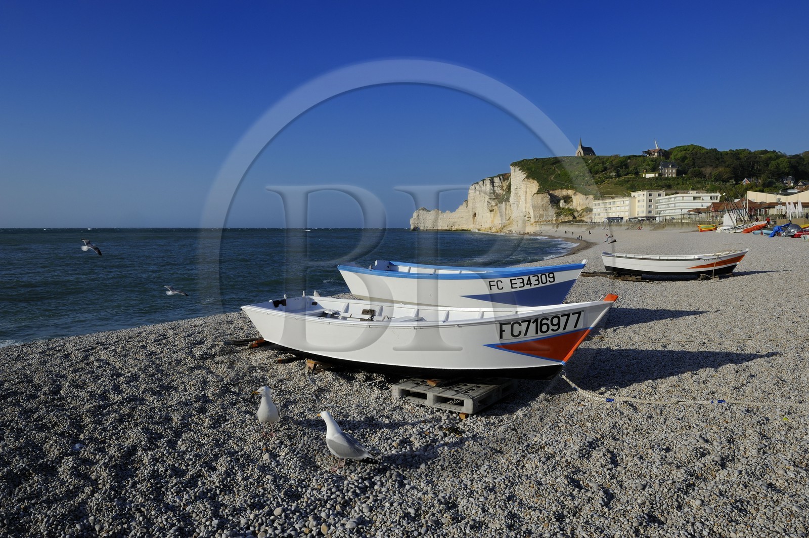 France, Seine-Maritime (76), Pays de Caux, Côte d'Albâtre, Etretat, la falaise d'Amont et l'église Notre-Dame-de-la-Garde depuis la plage de la ville avec les barques de pecheurs