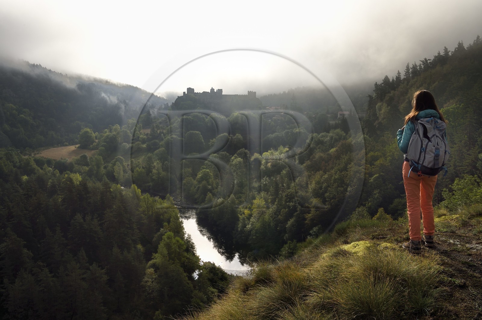 France, Haute-Loire (43), vallée de la Loire, Arlempdes, labellisé les Plus beaux villages de France, randonneuse observant les ruines du chateau perché sur un rocher basaltique qui surplombe un méandre de la Loire