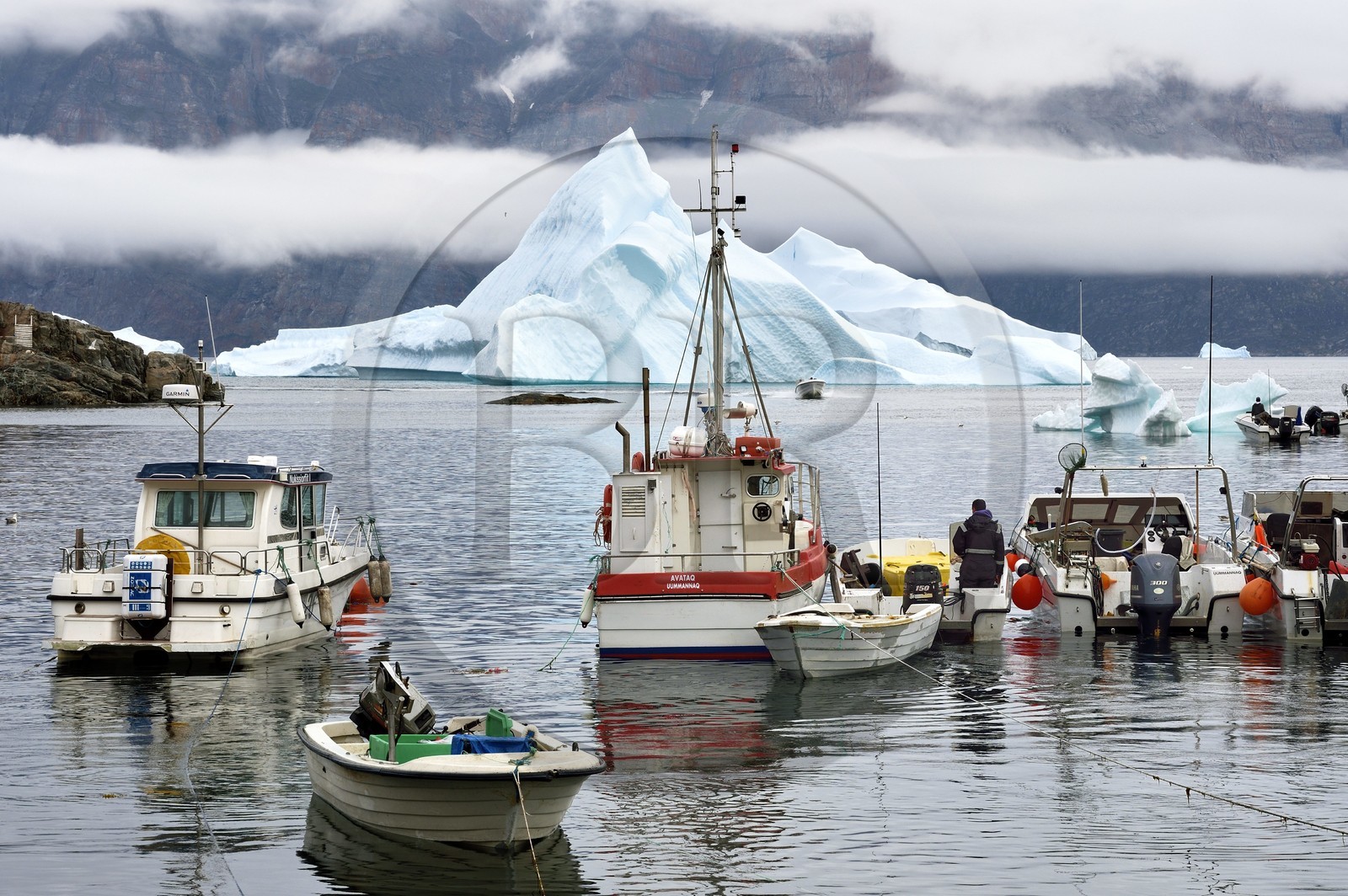 Groenland, cote ouest, Uummannaq, bateau de pêche dans le port et icebergs en arrière plan