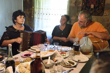 Georgia, Kakheti, Akhmeta, traditional festive meal in a Tusheti family, songs accompanied by accordion and drum