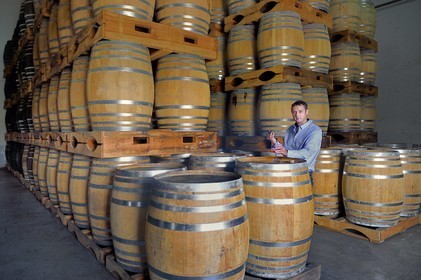 France, Reunion island (French overseas department), Saint Pierre, estate of the Isautier distillery, aging of old rums in the cellars between 6 and 14 months in new barrels then several years afterwards by batch in red barrels, Cyril Isautier director of the rums and punches branch of the Isautier group takes a sample with a pipette for tasting