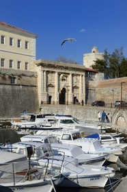 Croatia, Dalmatia, Dalmatian Coast, Zadar, Fosa port and the Kopnena vrata (Landward Gate) crowned with Venitian winged lion in the background