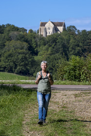 France, Yonne (89), Montréal (Bourgogne), randonneuse sur un chemin et la collégiale Notre-Dame en arrière plan