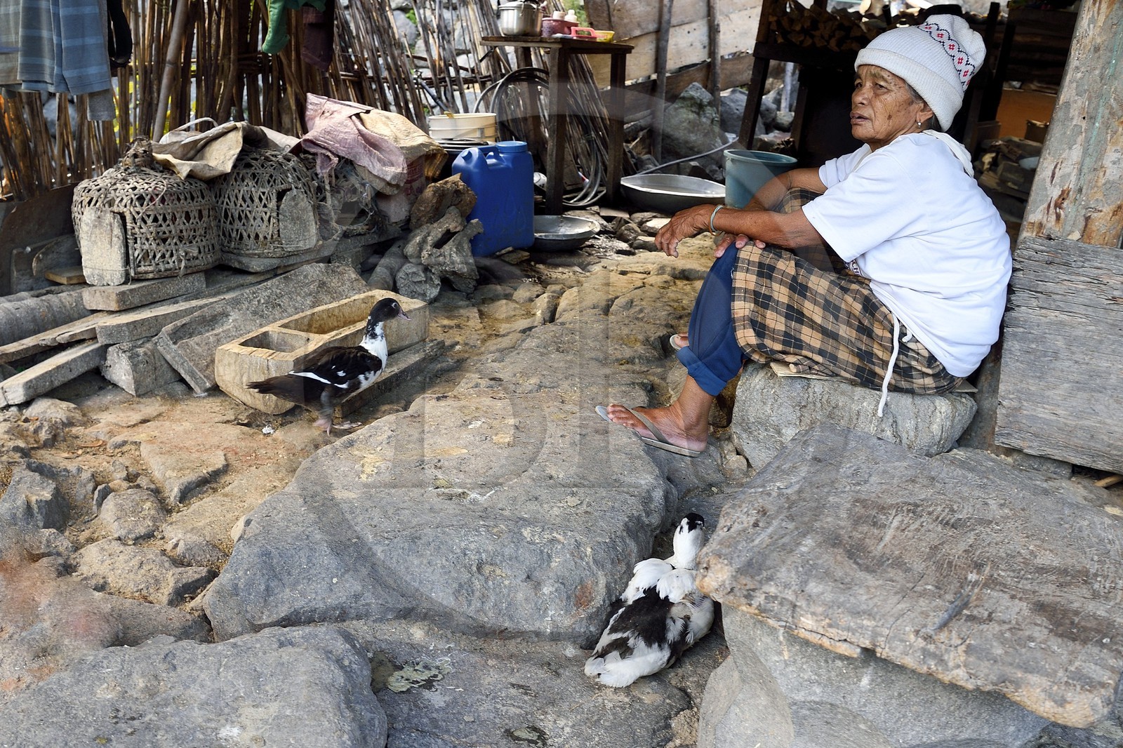 Philippines, province d'Ifugao, village de Batad, vieille femme assise au pied de sa maison