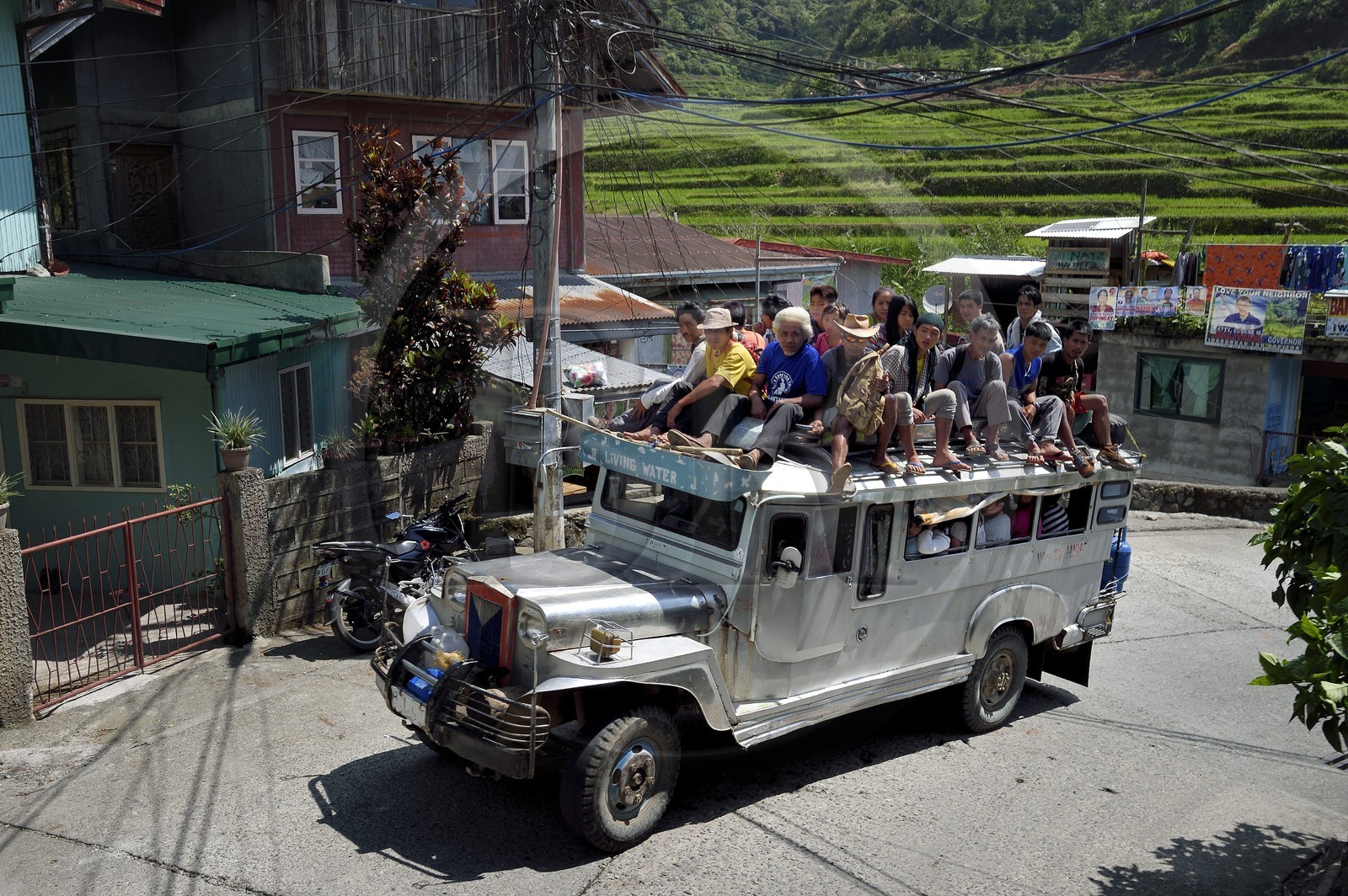 Philippines, Ifugao province, Banaue town, jeepney (elongated jeep to transport passengers) in the main street, passengers on the roof