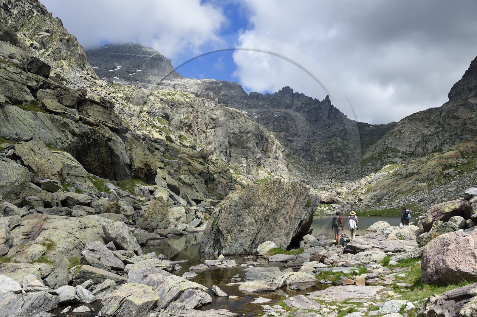 France, Alpes-Maritimes (06), parc national du Mercantour, Vallée des Merveilles parsemée de milliers de gravures rupestres de l'Age de bronze, randonneurs sur le sentier de randonnée GR 52 au lac des Merveilles en contrebas de la Baisse de Valmasque et le Mont du Grand Capelet (2915m) en arrière plan à gauche