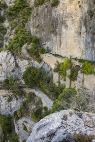 France, Herault, the Causses and the Cevennes, Mediterranean agro pastoral cultural landscape, listed as World Heritage by UNESCO, Saint Guilhem le Desert, labelled Les Plus Beaux Villages de France (The Most Beautiful Villages of France), hikers on the Via Tolosana on the way to Santiago de Compostela, the Passage des Fenestrelles once laid out by the monks of the abbey in Middle Ages in order to cross this rocky lock in the Cirque de l'Infernet
