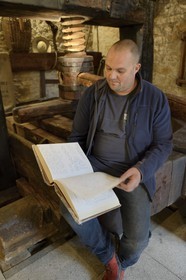 France, Bas-Rhin (67), Route des Vins d'Alsace, Mittelbergheim, labellisé Les Plus Beaux Villages de France, le musée viticole-conservatoire, le viticulteur Nicolas Wittmann consultant le livre historique des vendanges du village
