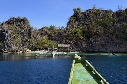 Philippines, Calamian Islands dans le nord de Palawan, Coron Island Natural Biotic Area, pirogue à balancier au pied des rochers de calcaire dans une petite crique