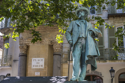 France, Bouches du Rhone, Arles, columns of Saint Lucian, half-pediment and two Corinthian capitals, the only remains of a small temple of the ancient Roman forum on the current place du Forum, listed as World heritage by UNESCO, the statue of Frédéric Mistral, Provencal writer (1830-1914)