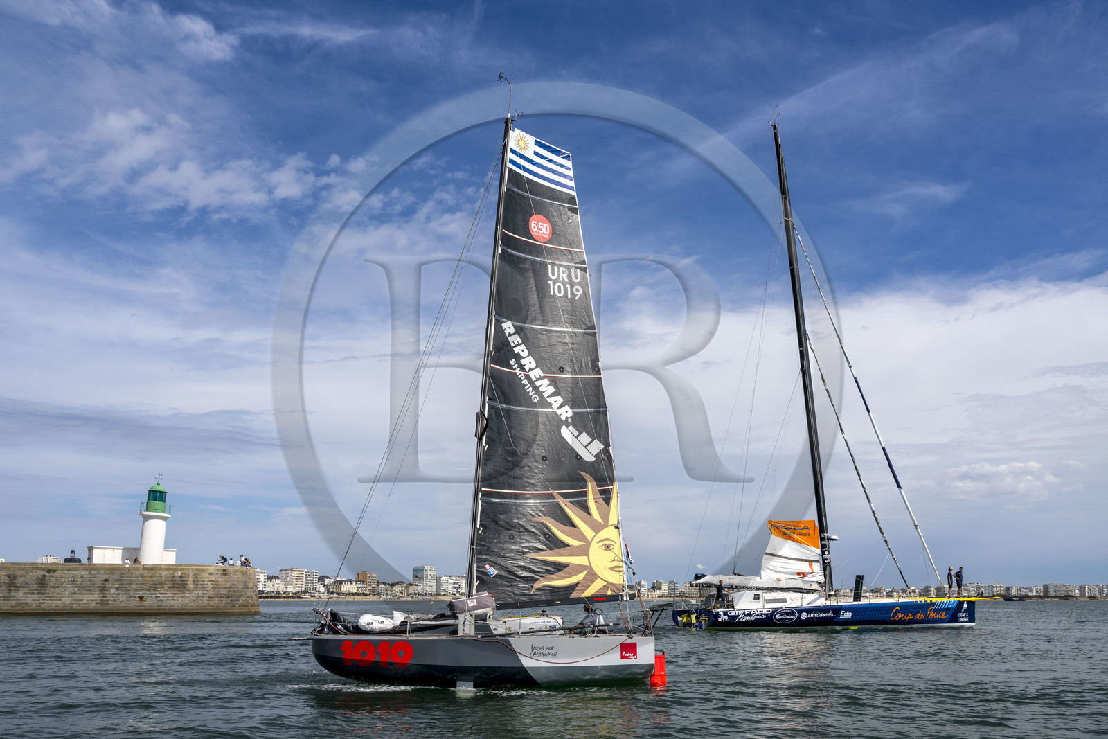 France, Vendée (85), Les-Sables-d'Olonne, un bateau à voile monocoque de régate de classe Mini 6,50 croise le voilier monocoque de 60 pieds IMOCA Coup de Pouce de Manuel Cousin à l'entrée du chenal