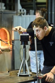 France, Moselle, Meisenthal, Centre international d'Art verrier (CIAV) (international glass centre), the blowing workshop, crafting a Christmas ball, installation of the pellet for the creation of the glass hook