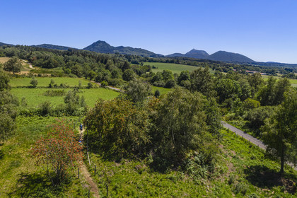 France, Puy-de-Dôme (63), Le Bouchet, Parc naturel régional des Volcans d'Auvergne, randonneur sur le sentier des puys de Jumes et de la Coquille, en arrière plan le volcan le Puy Chopine à gauche et le Puy de Dome à droite (vue aérienne)