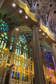 Spain, Catalonia, Barcelona, Eixample district, Sagrada Familia basilica by Catalan modernist architect Antoni Gaudi, listed as a UNESCO World Heritage Site, stained glass windows of the Nativity façade nave side by the Catalan painter and glassmaker Joan Vila-Grau illuminated by the warm projections of the stained glass windows on the Passion facade